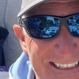 Capt. Kerrick smiling in a cap and sunglasses, close up