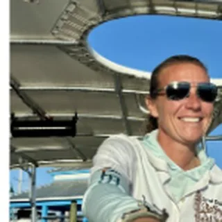 Capt. Lauren Malinowski smiling in sunglasses on the boat