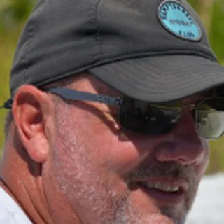 Capt. Paul O'Neill in a dark cap and sunglasses, seen from the side